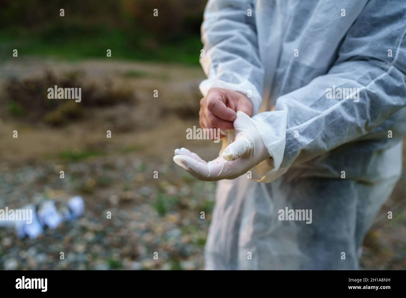 Le concept d'enquête sur le crime est à portée de main d'un médecin légiste inconnu qui met des gants en caoutchouc sur les lieux du crime pour recueillir des preuves Banque D'Images
