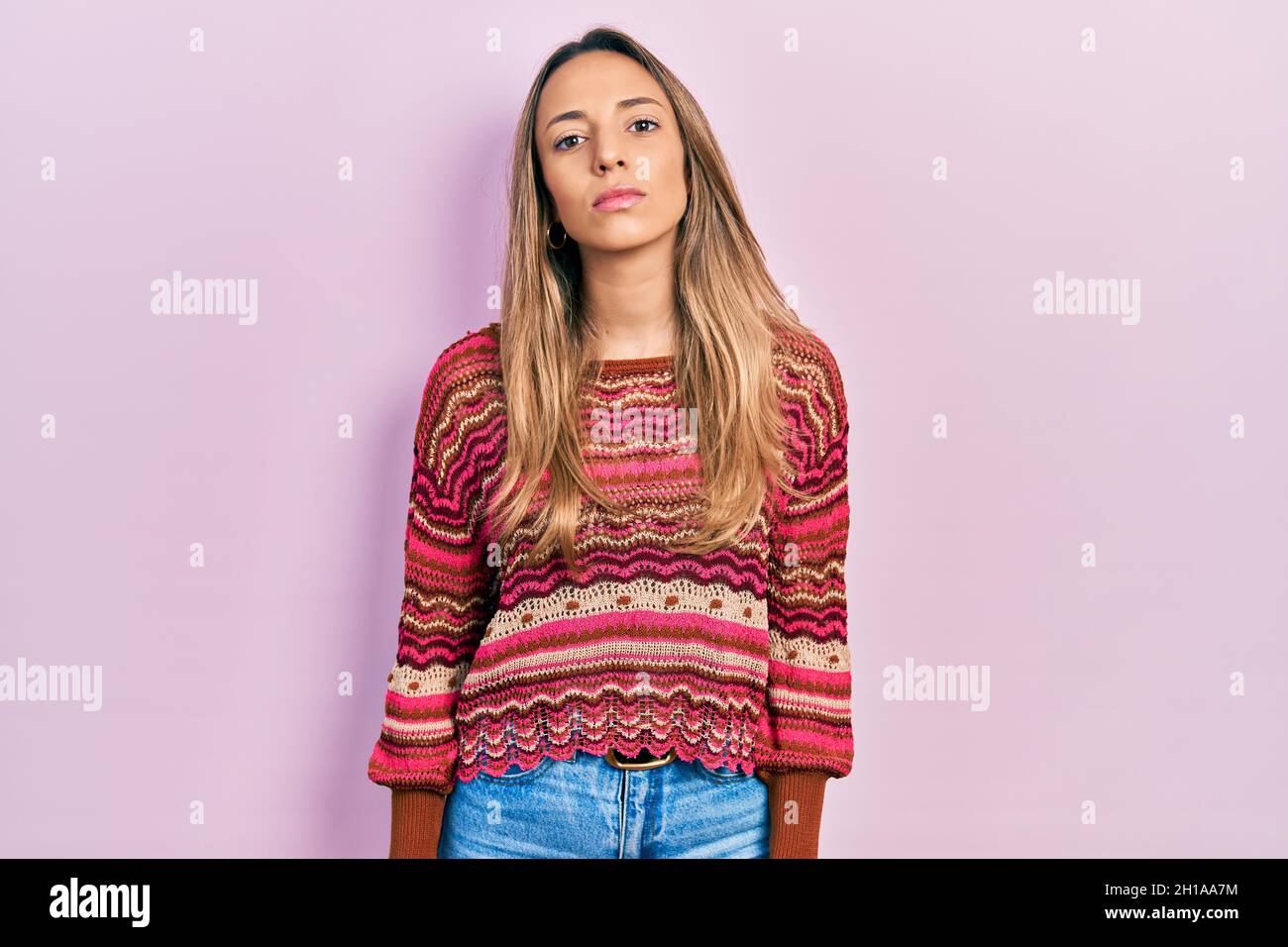 Belle femme hispanique portant un pull hippie décontracté avec une expression sérieuse sur le visage. Simple et naturel regarder l'appareil photo. Banque D'Images