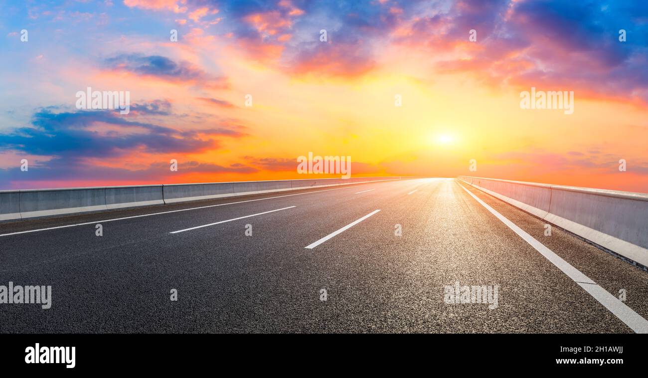 Route asphaltée et nuages de ciel au coucher du soleil.arrière-plan de route. Banque D'Images