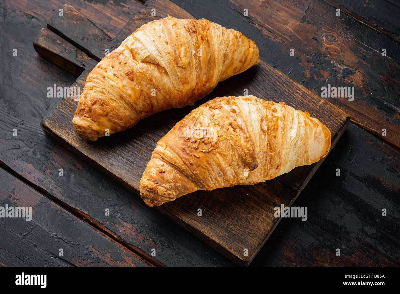 De savoureux croissants au beurre, sur fond de table en bois sombre, avec espace pour le texte Banque D'Images