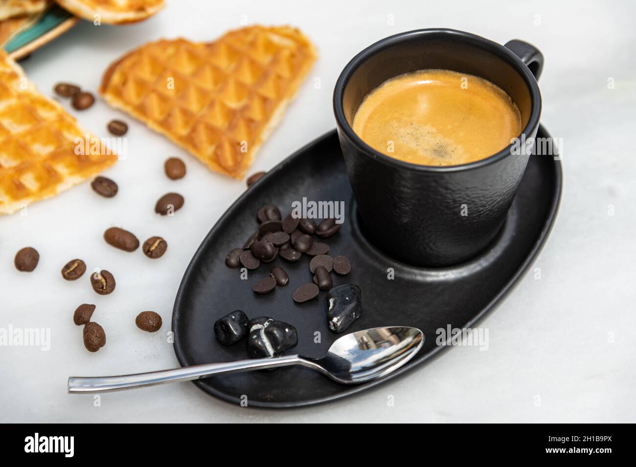 Café expresso frais avec grains de café sur fond de marbre blanc Banque D'Images