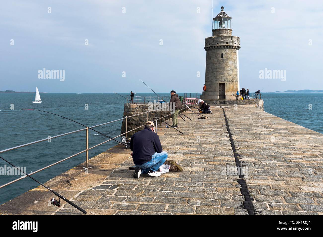 dh Castle Breakwater Lighthouse ST PETER PORT GUERNESEY personnes pêche de piers quai en pierre de granit Banque D'Images