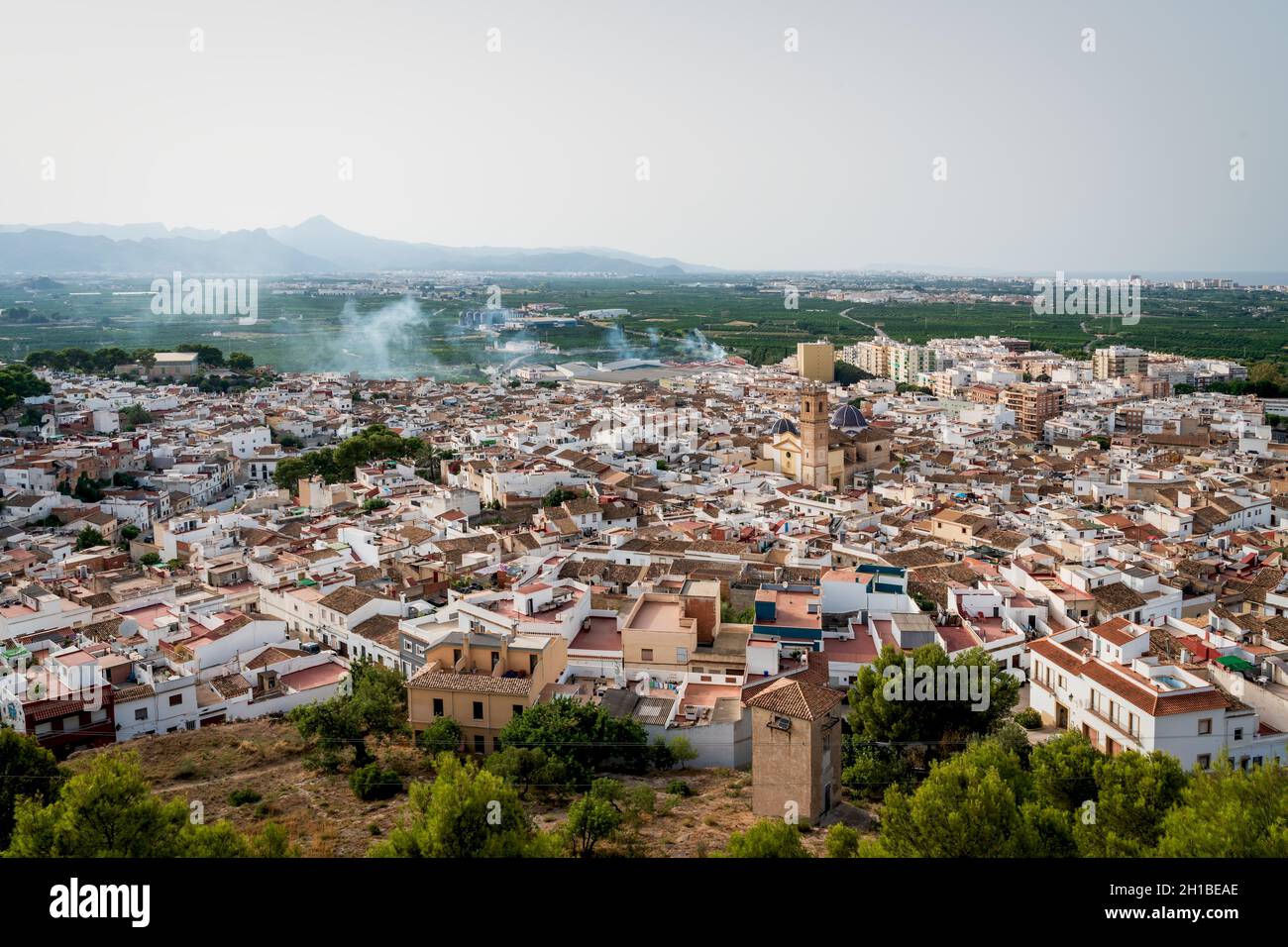 Vue aérienne du château de 'Santa Anna' sur la vieille ville espagnole avec la tour de l'église et les dômes carrelés de 'San Roque' dans le centre, Oliva, Espagne Banque D'Images