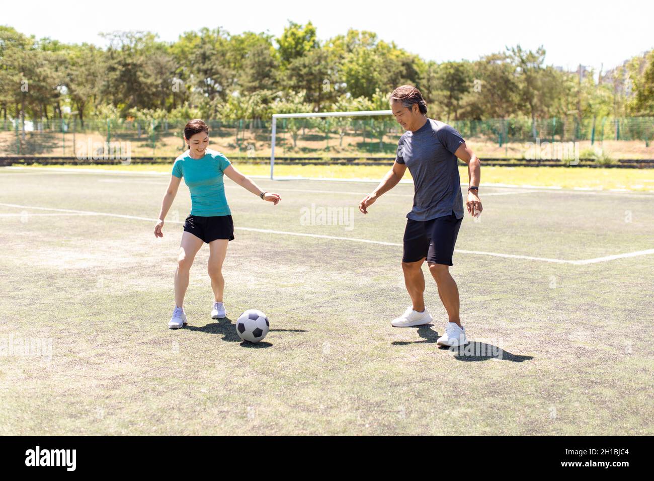 Couple d'âge mûr heureux jouant au football en plein air Banque D'Images