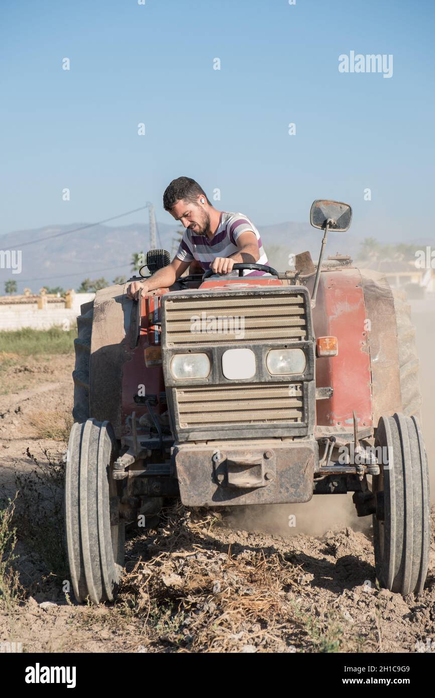 jeune agriculteur travaillant dans le champ avec un tracteur Banque D'Images