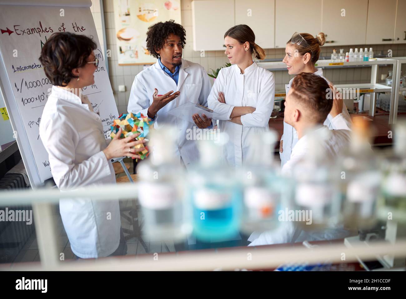 De jeunes collègues discutent d'une leçon de chimie dans le laboratoire universitaire dans une atmosphère détendue.Science, chimie, laboratoire, personnes Banque D'Images