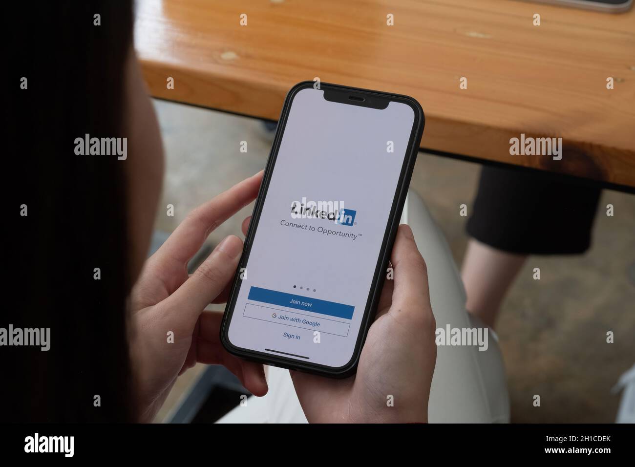 CHIANG MAI, THAÏLANDE, OCT 10, 2021 : Une femme détient Apple iPhone 12 avec application LinkedIn sur l'écran.LinkedIn est une application de partage de photos pour Banque D'Images
