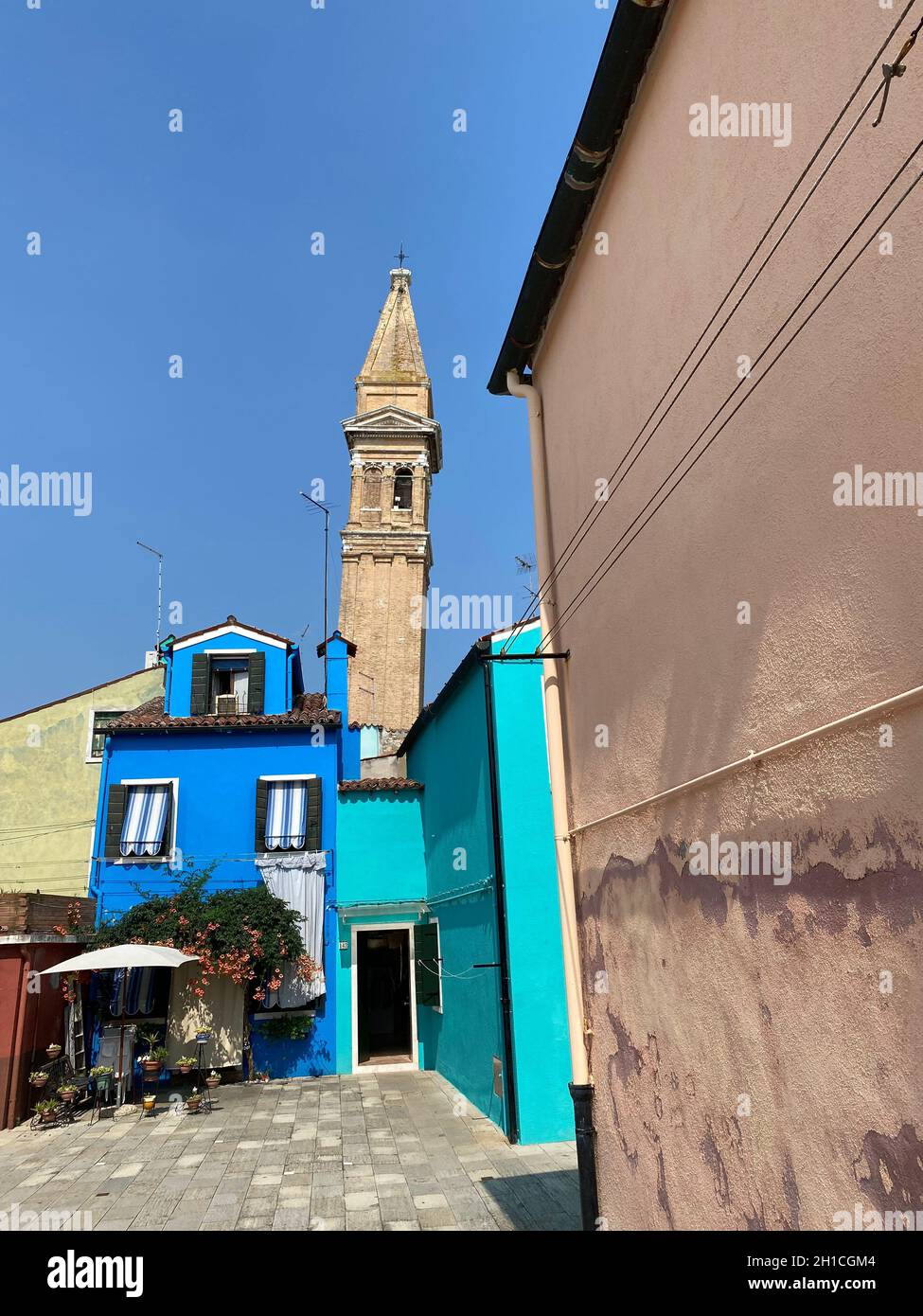 Maisons de façade peintes en couleur à Burano où le clocher pendu de l'église San Martino en arrière-plan, Voyage arrière-plan, Italie Banque D'Images