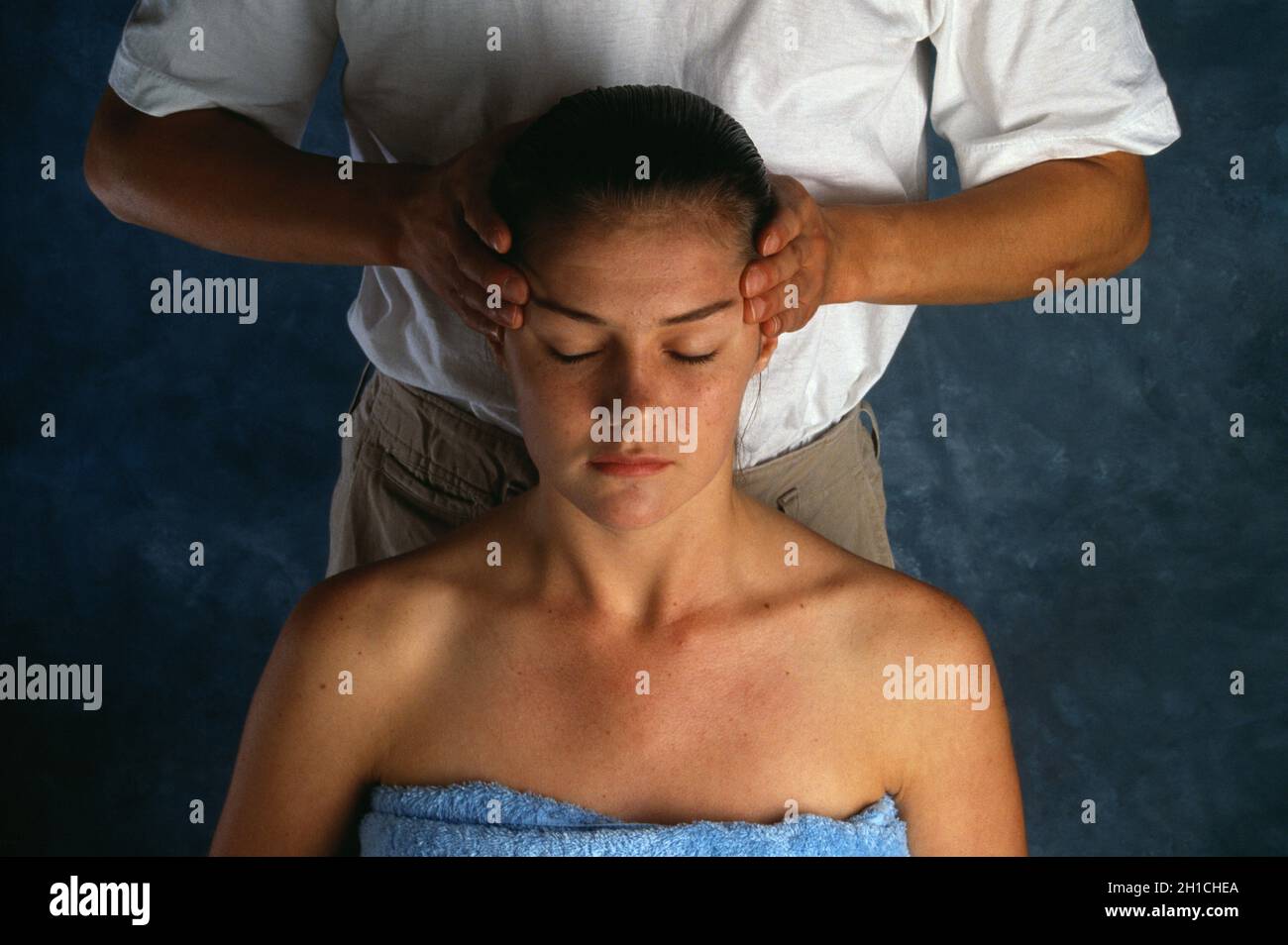 Kinésithérapeute massant la tête de la jeune femme. Banque D'Images