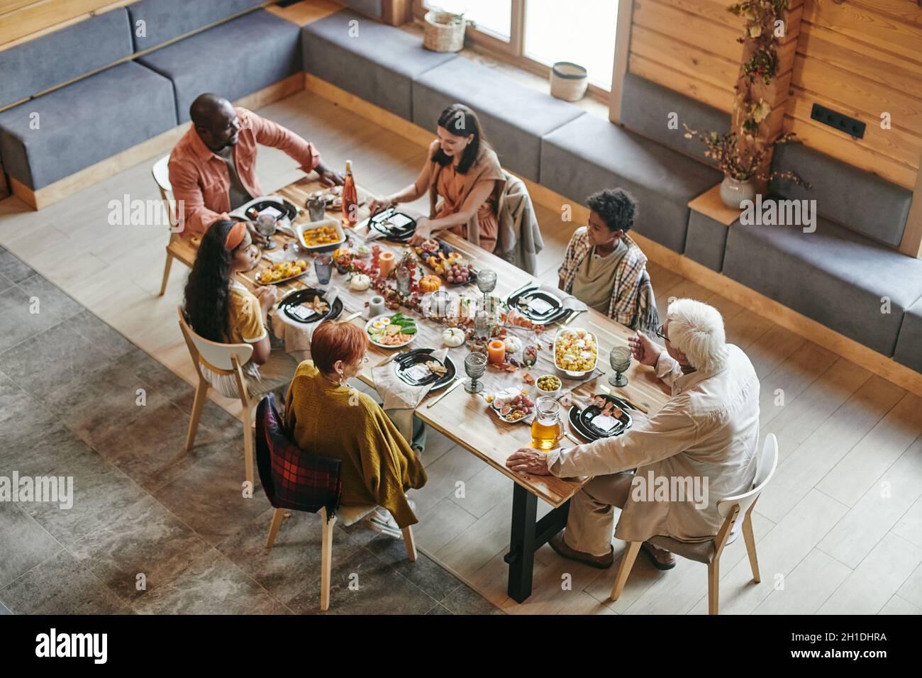 Vue en grand angle d'une grande famille assise à une table à manger et dîner ensemble dans la salle à manger à la maison Banque D'Images