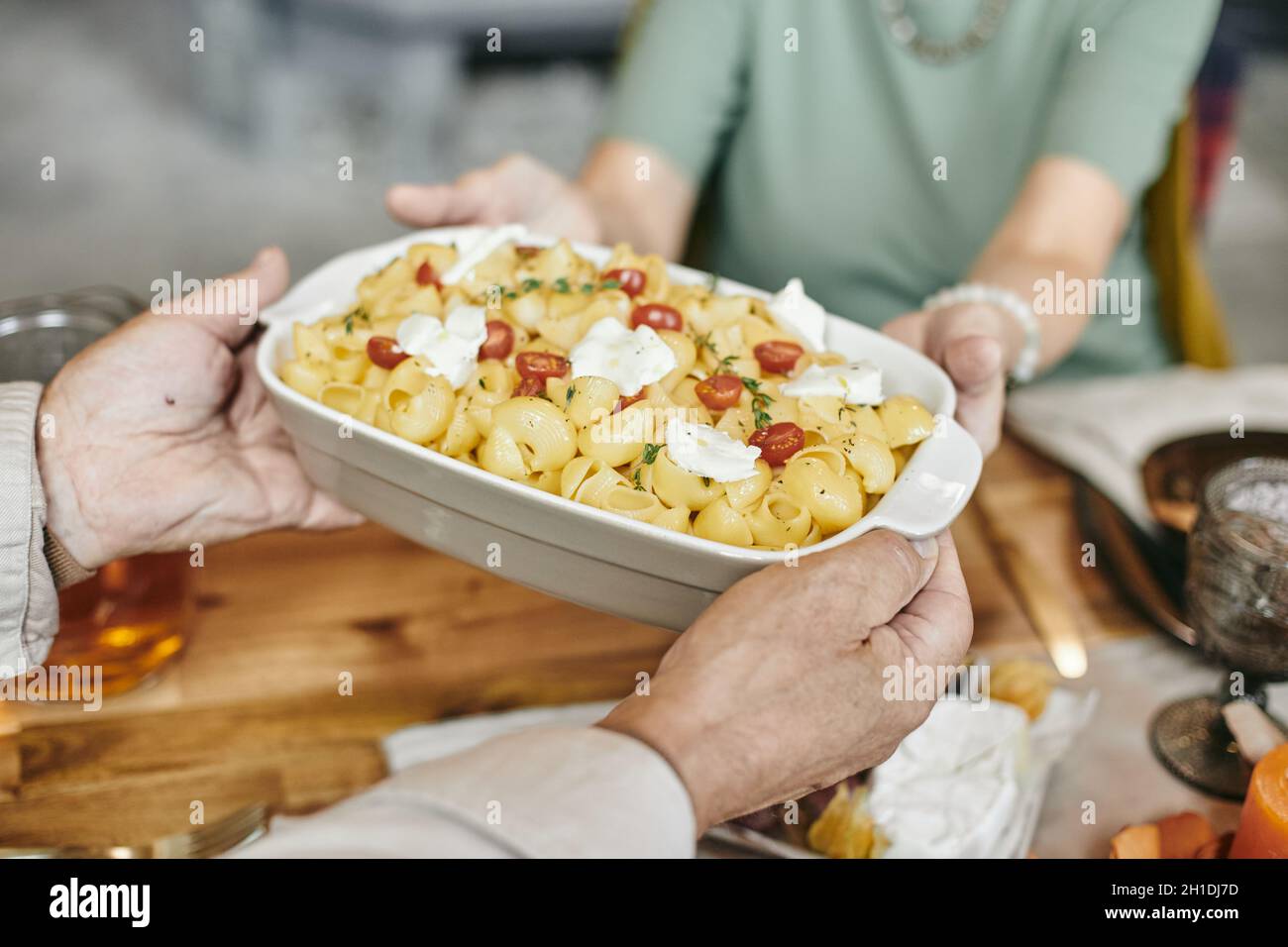 Gros plan de l'homme servant un dîner chaud pour sa famille à la table à manger Banque D'Images