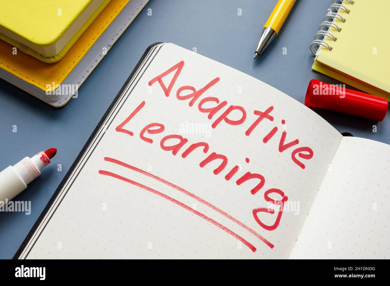 Enseigne manuscrite Adaptive Learning et livres jaunes. Banque D'Images