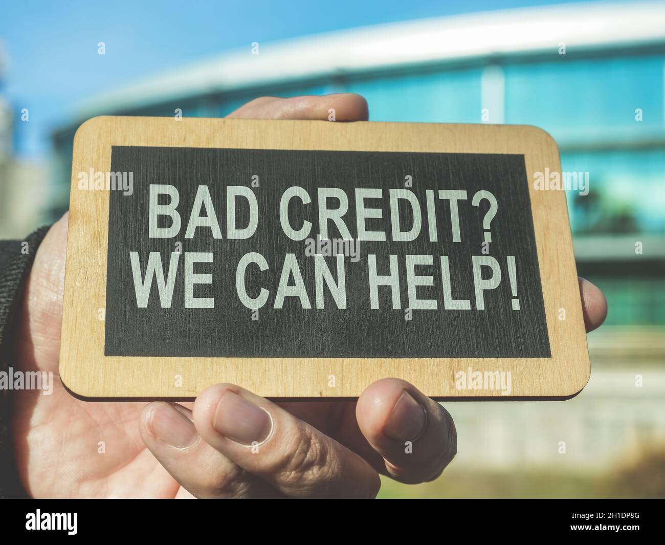 Une main tient un signe Bad crédit, nous pouvons aider. Banque D'Images