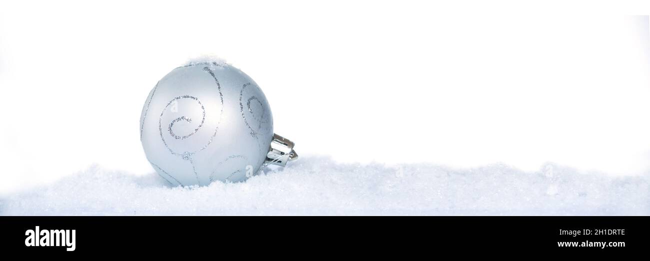 Gros plan d'une boule de noël blanche avec neige isolée sur fond blanc, bannière Web de vacances Banque D'Images
