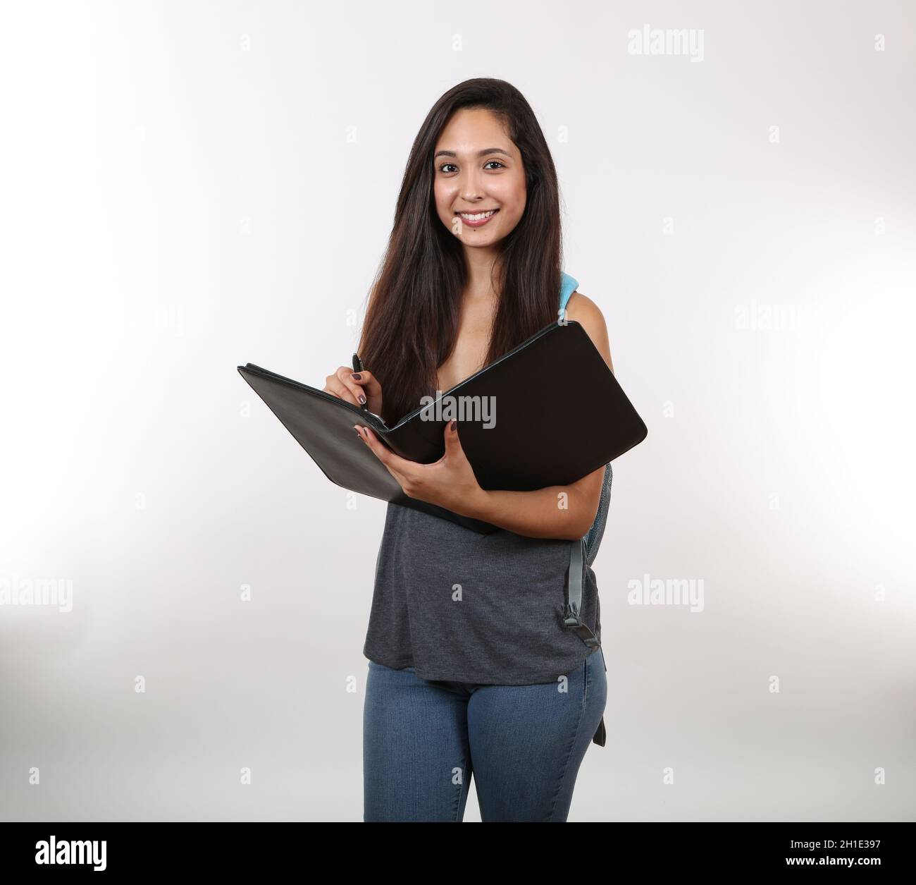 Un jeune étudiant se prépare à prendre des notes dans son portefeuille noir  tout en tenant son sac à dos Photo Stock - Alamy