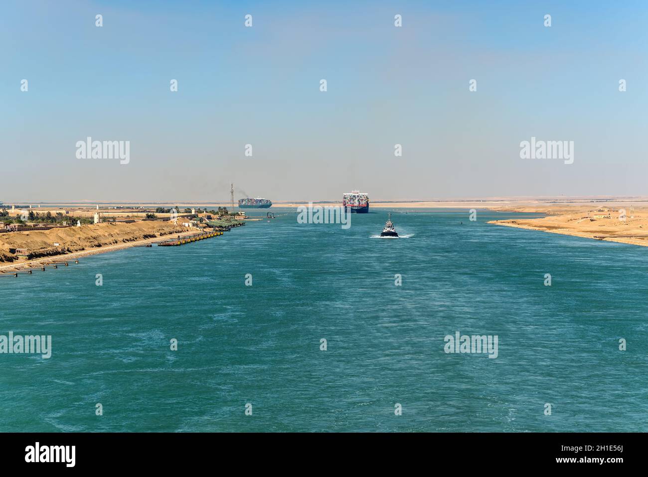 Suez, Egypte - Novembre 5, 2017 : grand récipient bateaux (navires) en passant le Canal de Suez dans la brume de sable près de Suez, Egypte, l'Afrique. Remorqueur accompagne shi Banque D'Images