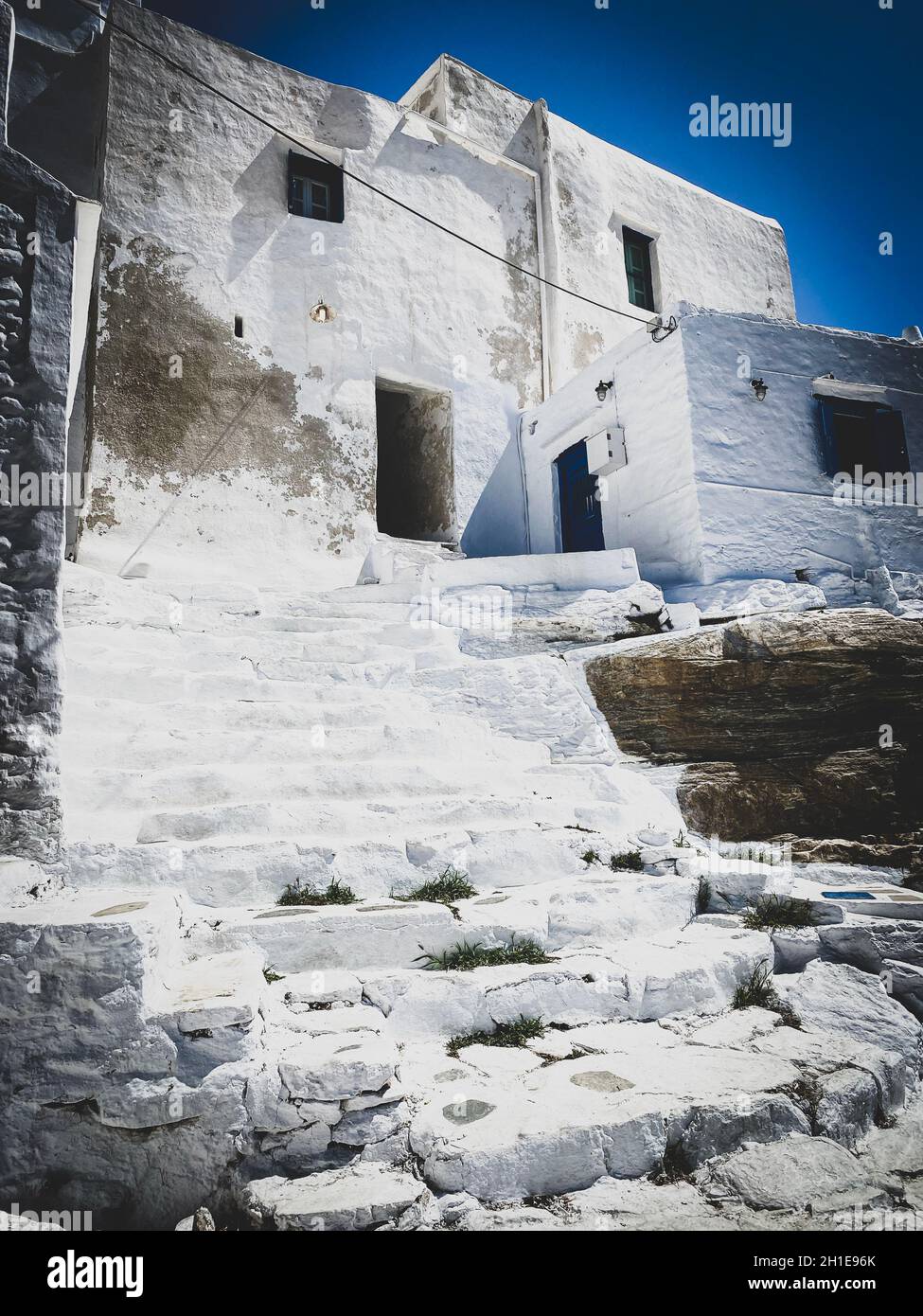 Architecture grecque traditionnelle, escaliers, murs blanchis à la chaux et portes bleues au village de Kastro Banque D'Images