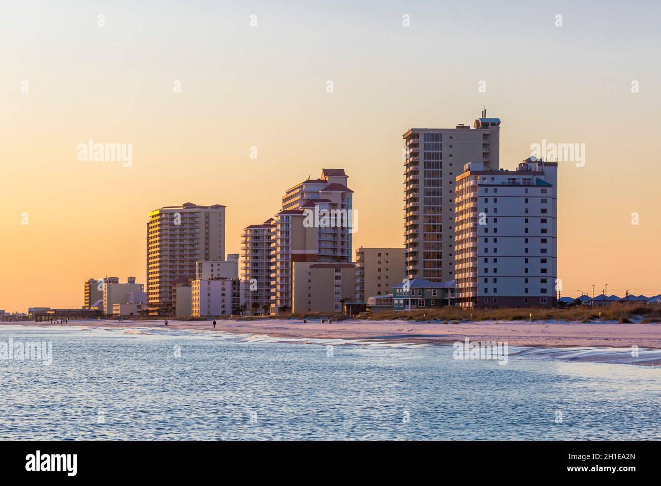 Hôtels et condominiums éclairés par le soleil couchant au crépuscule le long de la plage de Gulf Shores, Alabama Banque D'Images