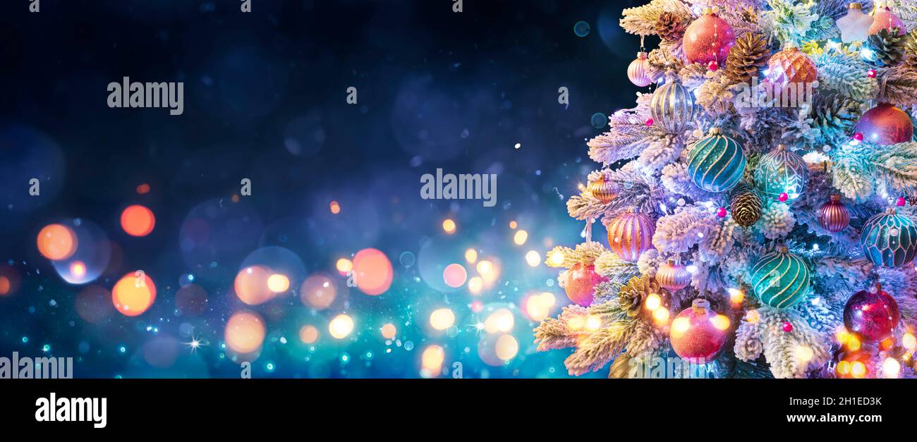 Sapin de Noël avec ornements en bleu nuit - boules sur branches de sapin avec lumières défocused en arrière-plan abstrait Banque D'Images