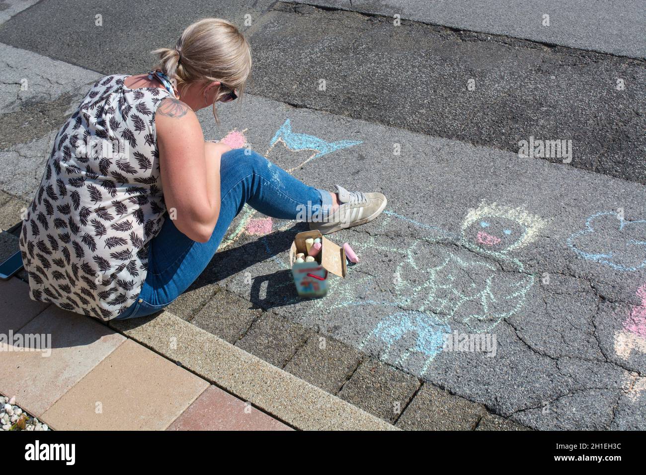 Dessin d'une jeune femme avec Kreide sur le malt d'asphalte. Körgerstraße 1, auf Ashaltbürgersteig Außentätigkeiten für Künstler. DRA Banque D'Images