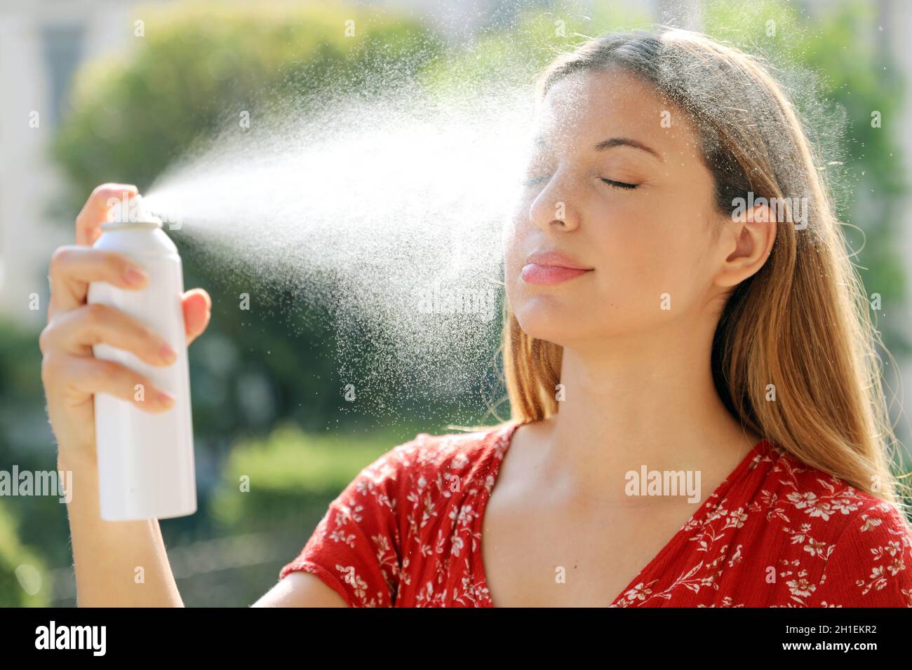 Jeune femme appliquant de l'eau thermique sur le visage extérieur. Eau  thermique utilisée pour les soins de la peau, maquillage fixe, aide à  l'irritation de la peau, rougeur et piqûres d'insectes Photo