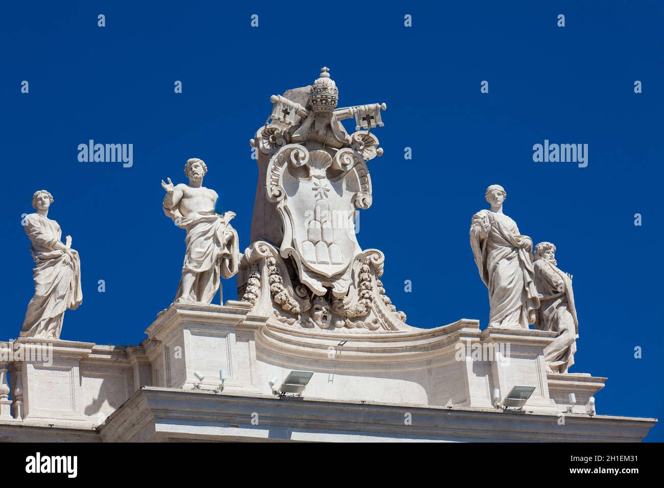 Détail de l'Chigi blasons et les statues de saints qui couronne les colonnades de Place Saint Pierre construite sur 1667 sur la Cité du Vatican Banque D'Images