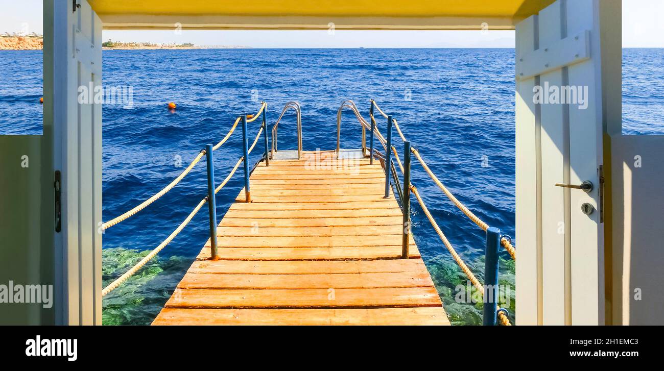 Le pont de bois et l'escalier dans l'eau à la plage avec les récifs coralliens à journée ensoleillée à Charm el Cheikh, Egypte Banque D'Images