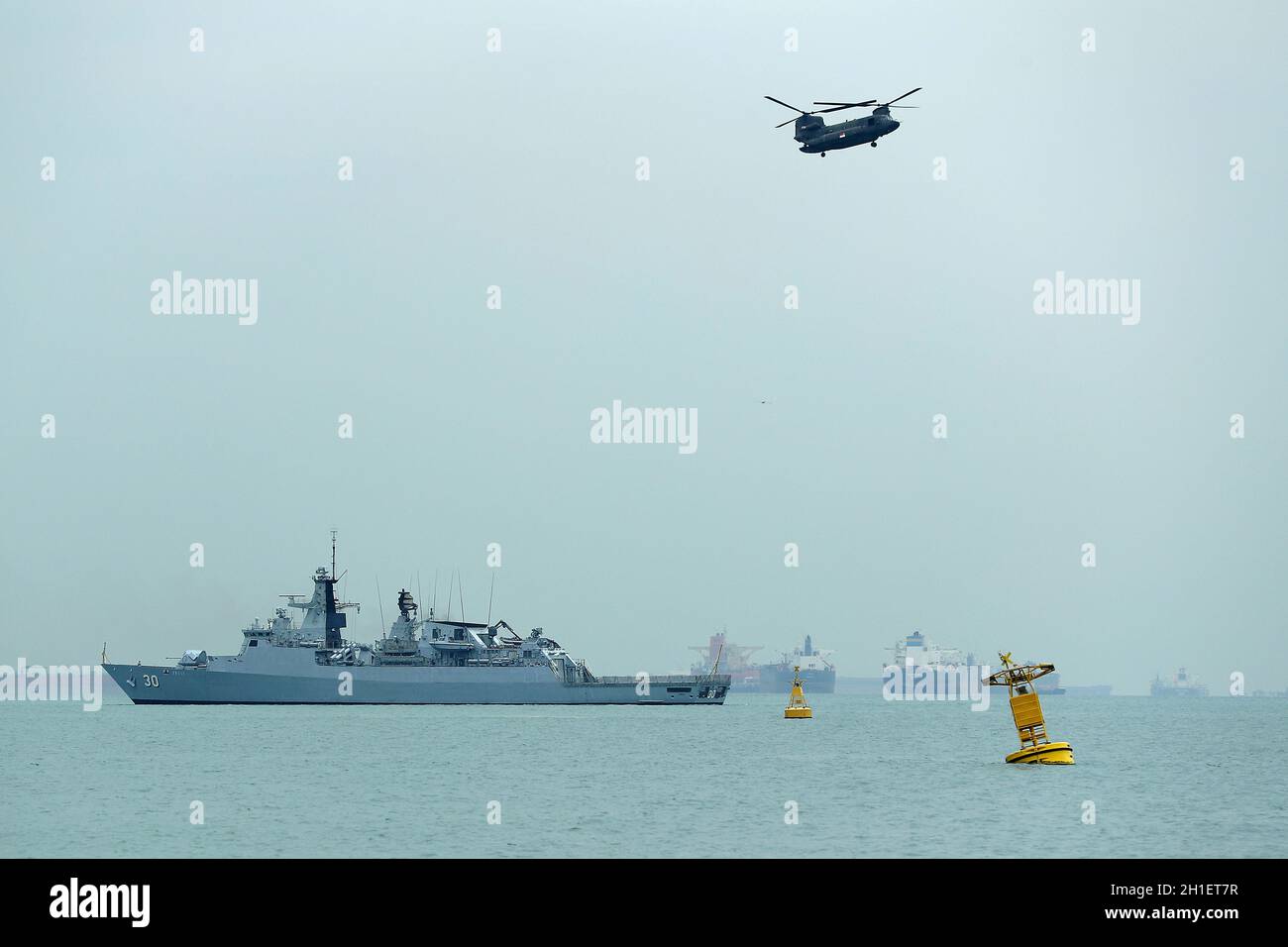 KD Lekiu (30) de la Marine royale malaisienne et d'un hélicoptère Chinook de la Force aérienne de la République de Singapour vu pendant les cinq arrangements de défense de puissance (FPDA) 50ème anniversaire flotte et exposition navale sur les eaux au large de Marina South. Les cinq États membres de la Force de défense de puissance (FPDA) - Australie, Malaisie, Nouvelle-Zélande, Singapour,Et le Royaume-Uni - commémorera le 50e anniversaire de la FPDA cette année, avec un flicast et un navire de marine exposé par les nations membres à la fin de l'exercice Bersama Gold 2021. Banque D'Images