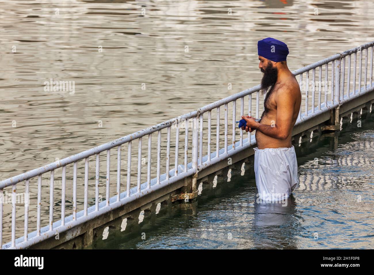 AMRITSAR, INDE - 26 AOÛT 2011 : homme sikh priant et se baignant dans un réservoir Saint autour de Harmandir Sahib Banque D'Images