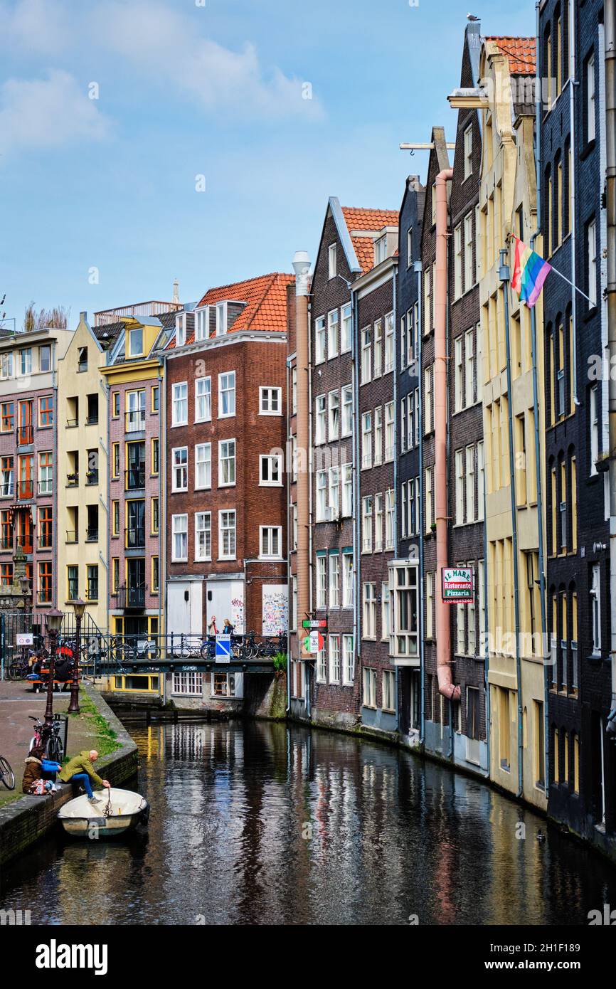 AMSTERDAM, PAYS-BAS - 7 MAI 2017 : canal d'Amsterdam avec bateau, pont et maisons anciennes avec drapeau arc-en-ciel gay Pride.En 2001, les pays-Bas sont devenus le Banque D'Images