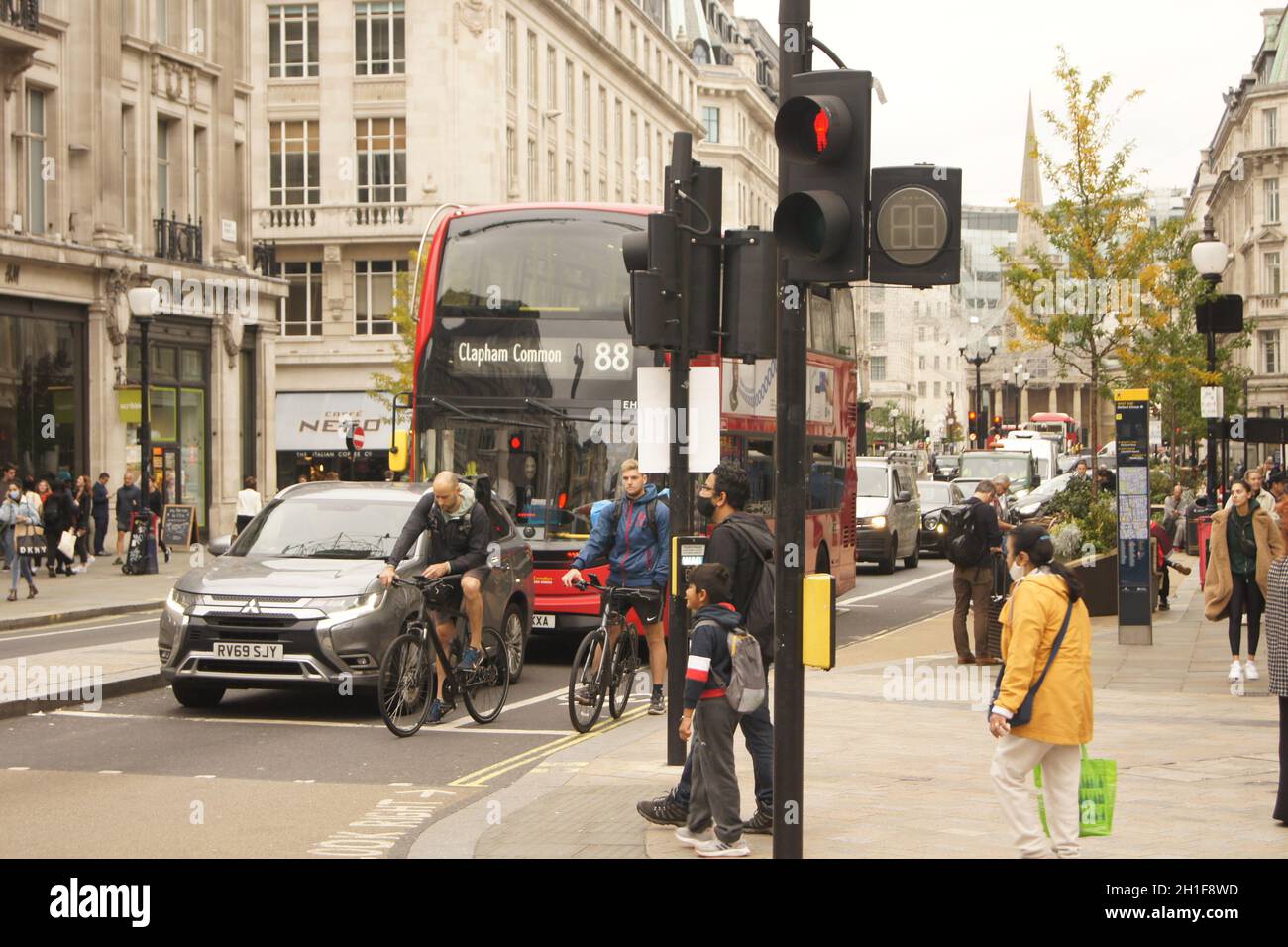 Des cyclistes, des piétons, des voitures et un bus attendent au feu de signalisation d'Oxford Circus dans le centre de Londres Banque D'Images