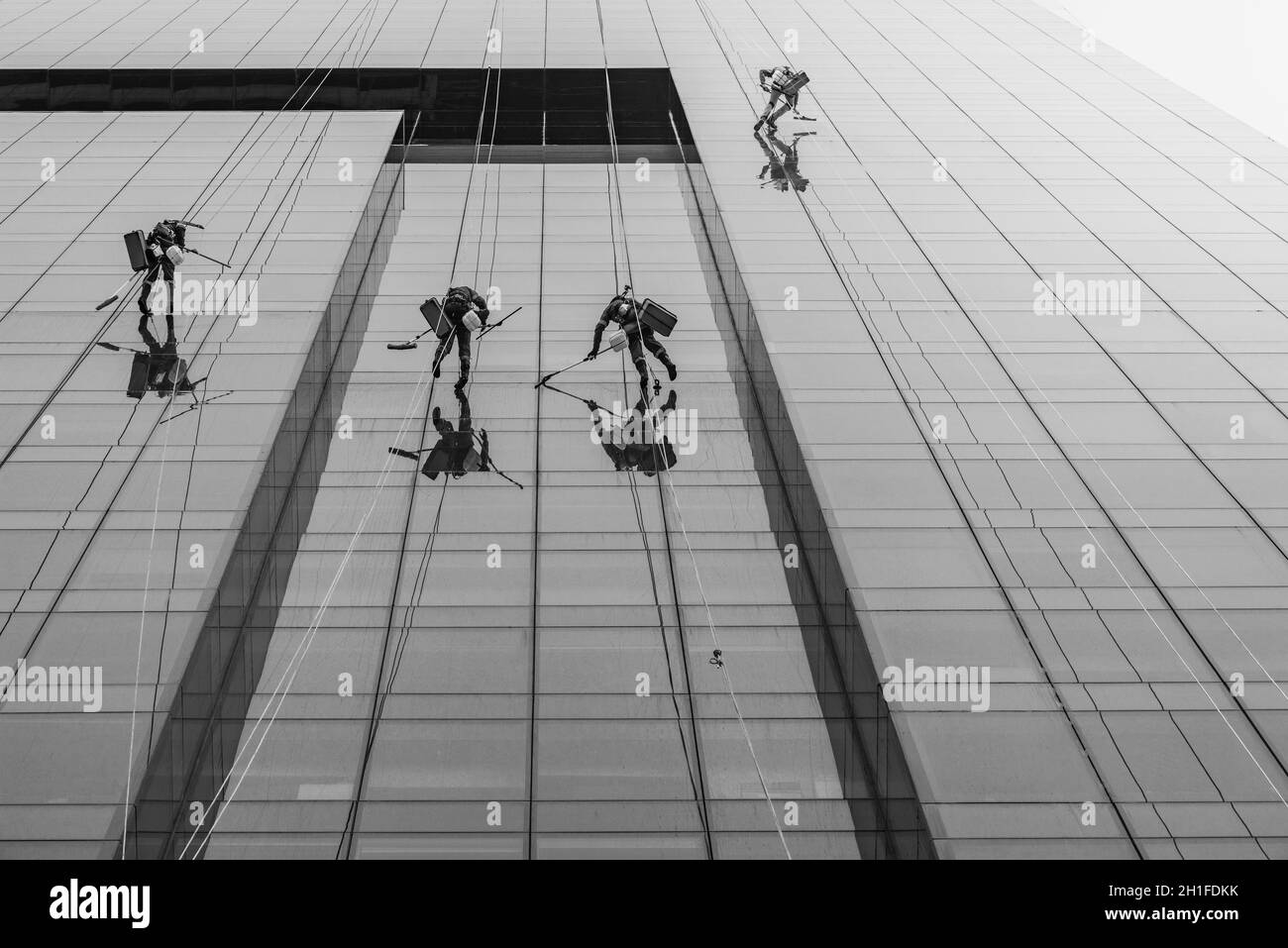 Les hommes se lavent des fenêtres du gratte-ciel moderne. Banque D'Images