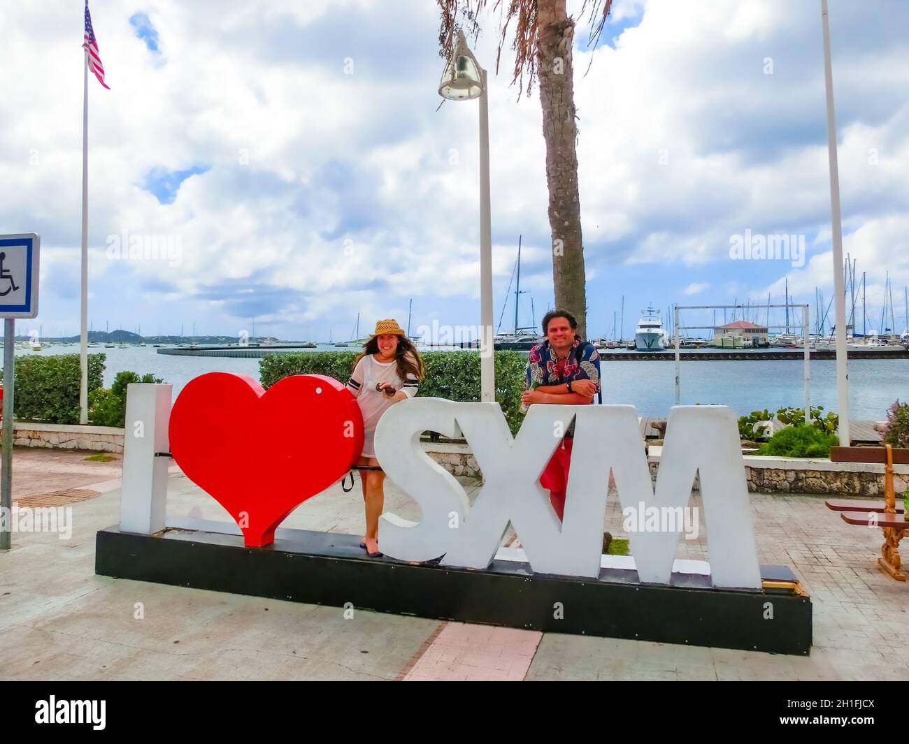 Marigot, Sint Maarten - 14 mai 2016: Le couple posant près du signe et de la statue J'aime Saint Martin à Marigot, île de St Maarten Banque D'Images