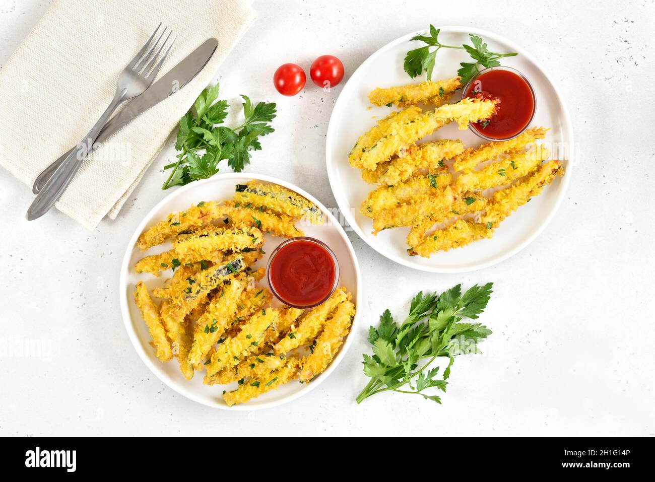 Bâtonnets de courgettes frits croustillants avec chapelure et sauce aux tomates sur plaque sur fond de pierre légère.Vue de dessus, plan d'appartement Banque D'Images