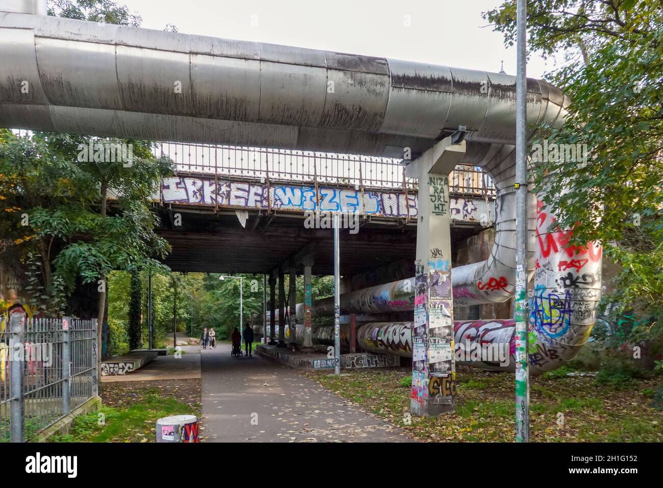 Leipzig, Allemagne.17 octobre 2021.Les conduites de chauffage de quartier (r.) passent sous le pont Riebeckstraße le long du chemin de marche et de vélo de la 'Anger-Crottendorfer Bahnschneise'.Le chemin forme une liaison directe entre le parc Lene-Voigt et le « Green Ring » autour de Leipzig.Sur l'ancien site ferroviaire, les cyclistes et les randonneurs peuvent profiter de la nature loin de la circulation routière et du bruit, au milieu du développement dense de l'est de Leipzig.Credit: Peter Endig/dpa-Zentralbild/ZB/dpa/Alay Live News Banque D'Images
