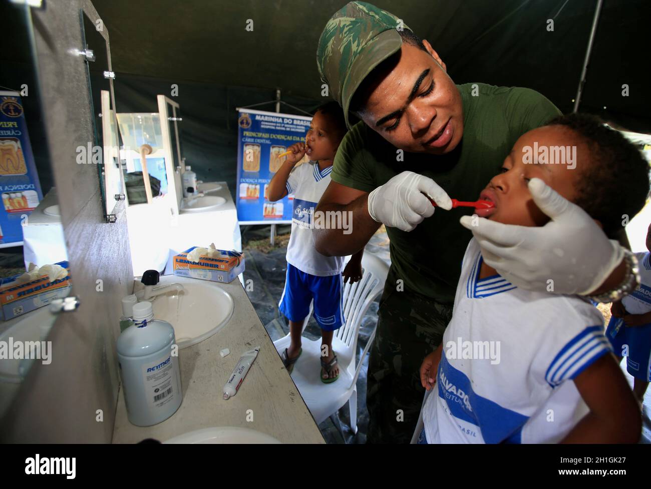 salvador, bahia / brésil - 4 novembre 2015: un militaire de la marine brésilienne enseigne à un enfant de se brosser les dents pendant l'action sociale sur l'islan Banque D'Images