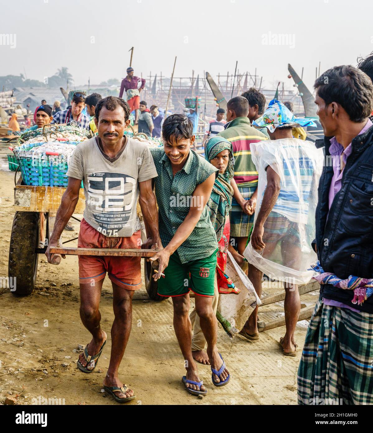 Chittagong, Bangladesh, 23 décembre 2017 : les pêcheurs tirent la charrette avec des captures fraîches de crevettes sur un marché de Chittagong, au Bangladesh Banque D'Images