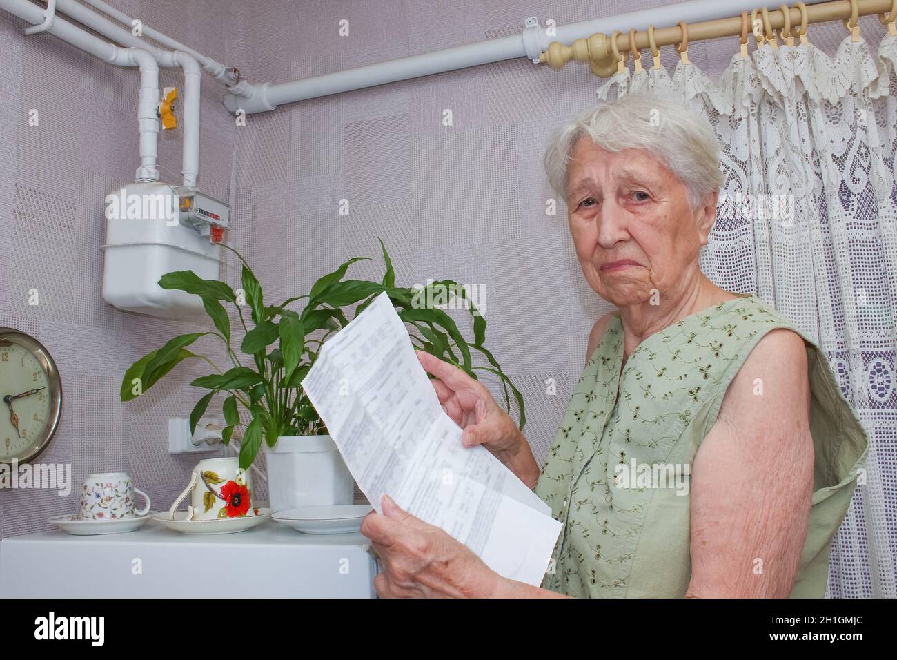 La triste femme âgée à la maison et examine la facture d'essence.Elle est soumise à des contraintes lors de la vérification des comptes. Banque D'Images