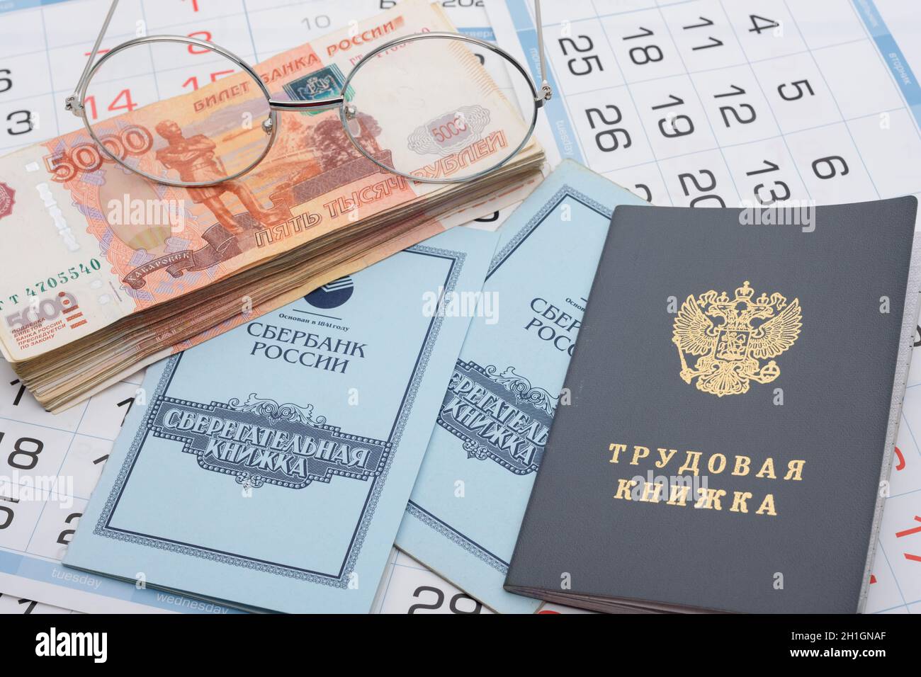 Anapa, Russie - 29.06.2020: Épargne et livre de travail, un paquet de roubles et de lunettes russes se trouvent sur le calendrier Banque D'Images