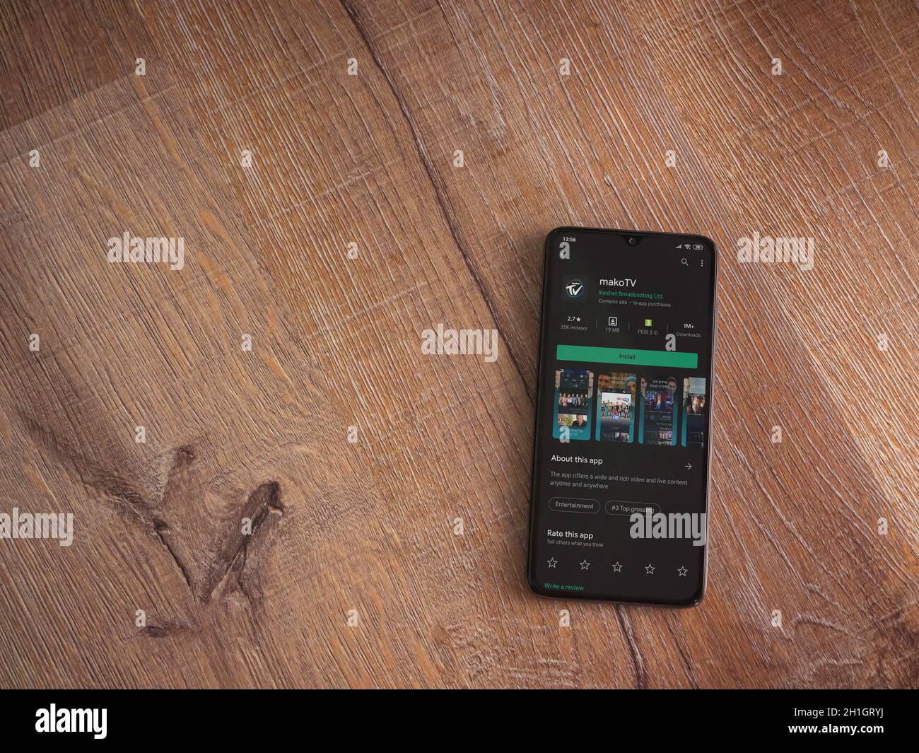 LOD, Israël - 8 juillet 2020 : page de la boutique de lecture de  l'application mako TV sur l'écran d'un smartphone mobile noir sur fond de  bois. Vue de dessus de la