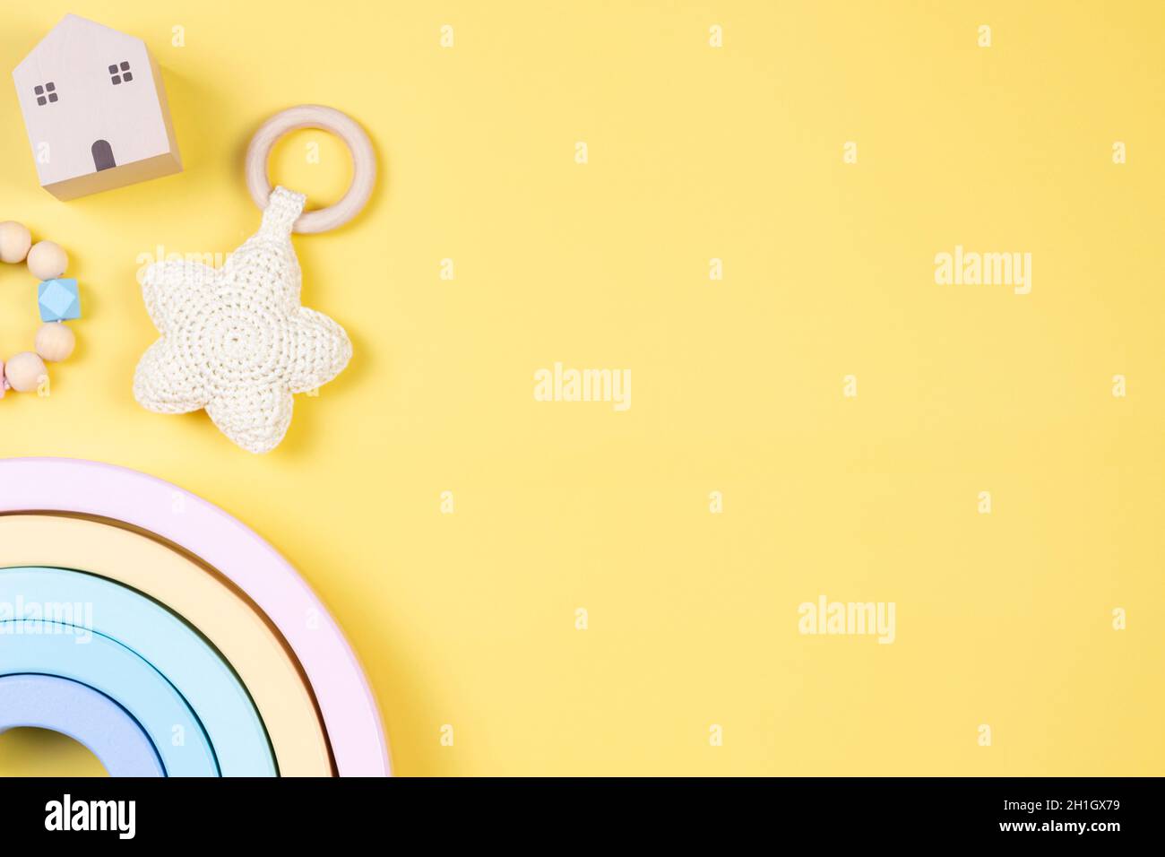 Jouets pour enfants sur fond jaune. Développement durable de la petite enfance produits pour bébés et jouets en bois de couleur pastel Banque D'Images