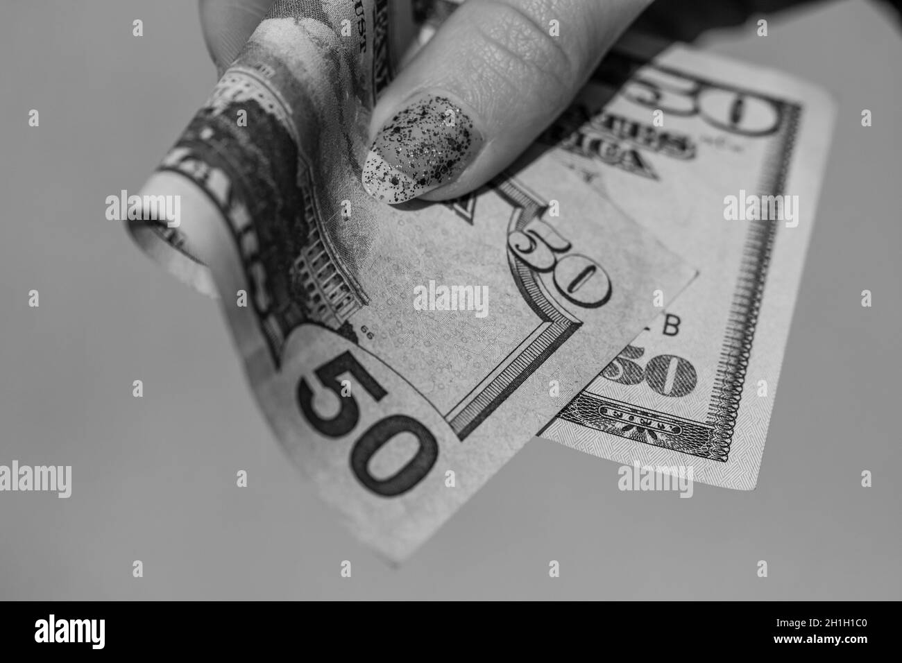 Mains donnant de l'argent comme un pot-de-vin ou des conseils. Détenir des billets de banque en dollars américains sur un fond flou, la monnaie américaine Banque D'Images