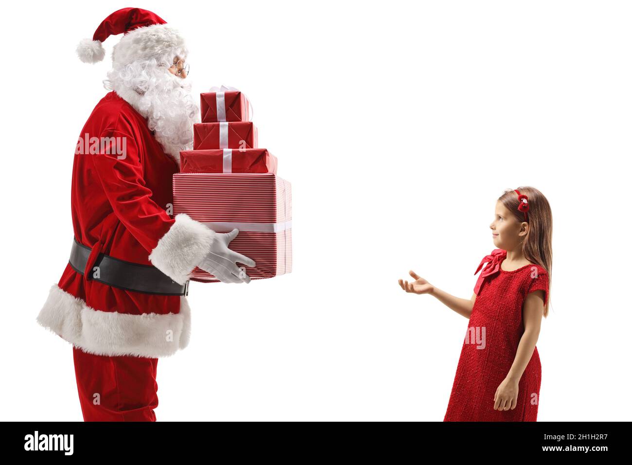 Photo de profil du Père Noël donnant des cadeaux à une fille dans une robe rouge isolée sur fond blanc Banque D'Images