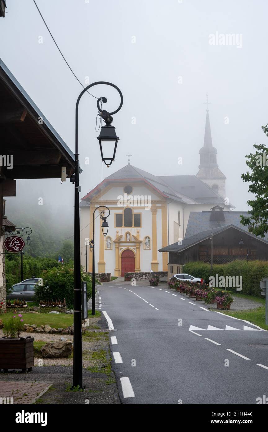 Vue sur la chapelle de montagne dans le petit village brumeux près de Saint-Gervais-les-bains, Savoie, France en été Banque D'Images