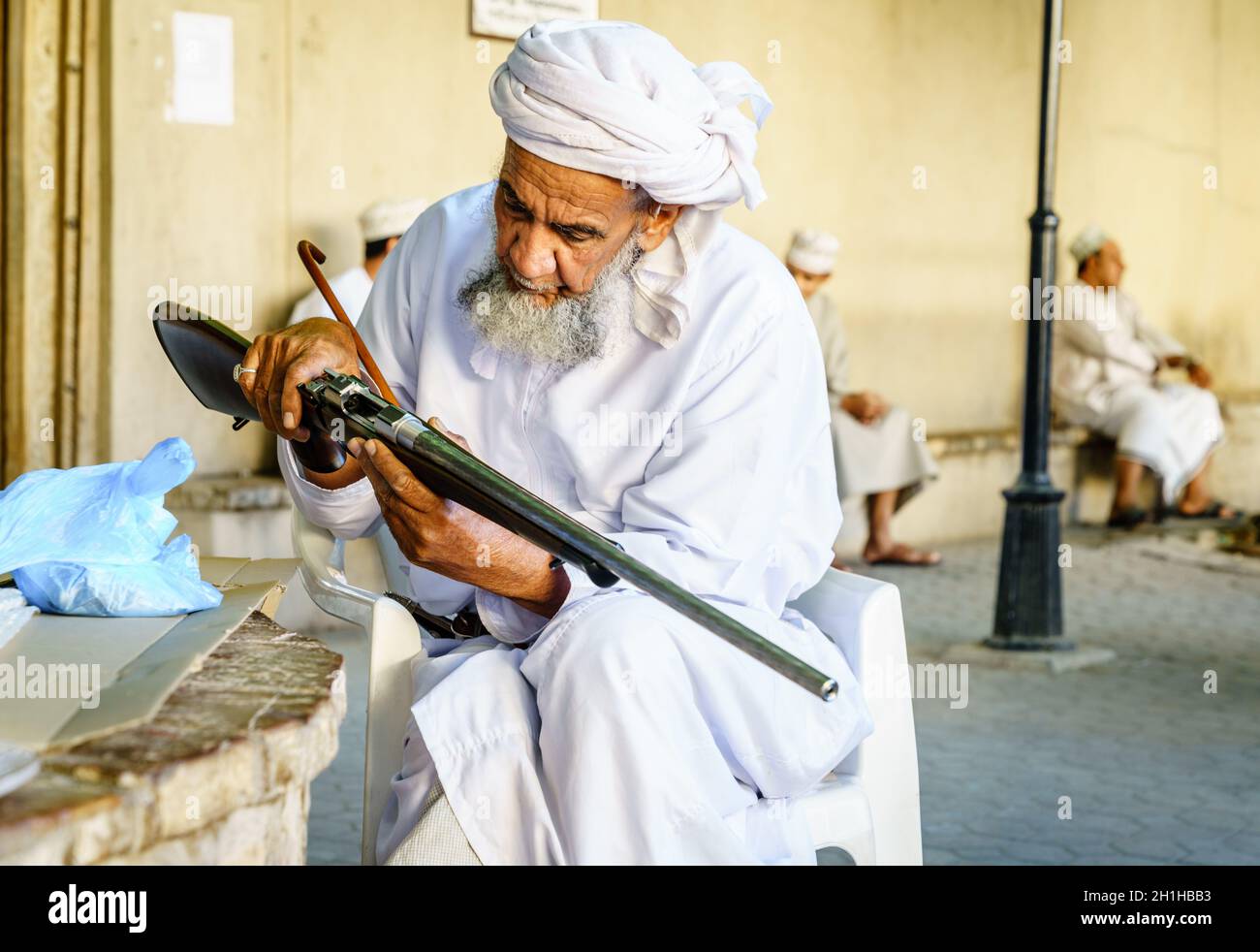 Nizwa, Oman, 2 décembre 2016 : un homme âgé inspecte une carabine de chasse au marché des armes du vendredi à Nizwa, en Omam Banque D'Images