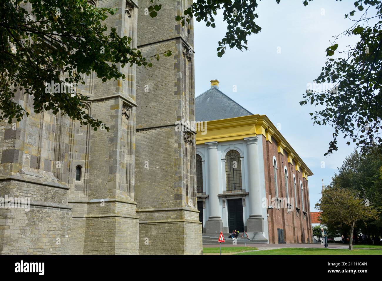 Partie de la vieille tour de Sint-Lievens - monstertoren, avec vue sur la nouvelle église dans la vieille ville de Zieriksee, pays-Bas avec ciel et arbres Banque D'Images