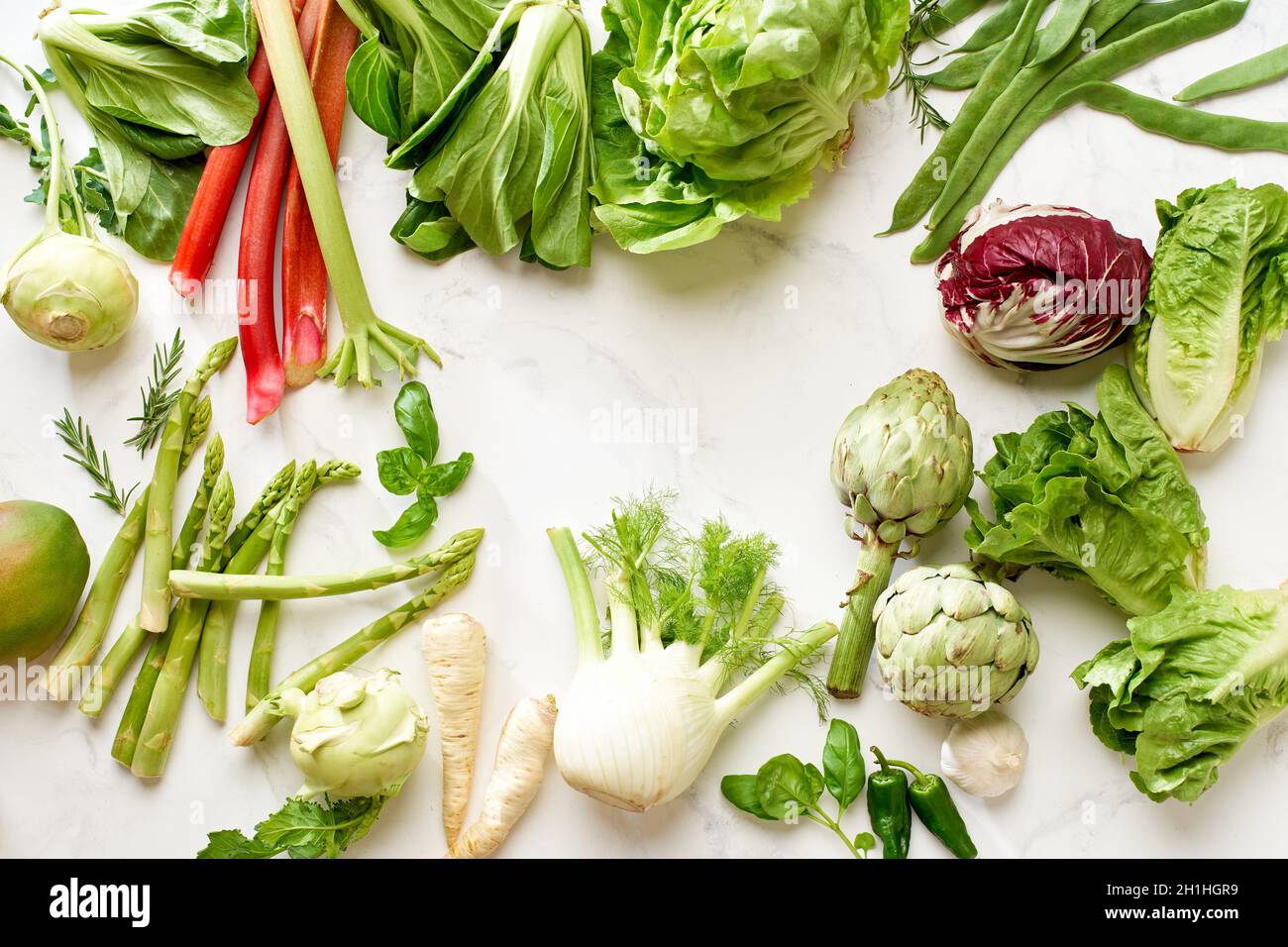 Plat avec ingrédients alimentaires végétaliens : salade et légumes vue de dessus sur table en marbre blanc avec espace pour copier dans le cadre Banque D'Images