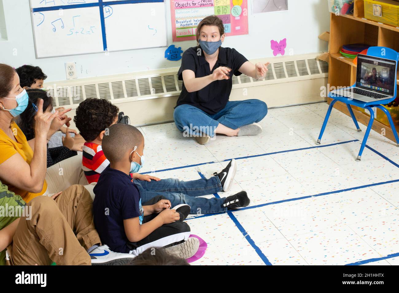 Éducation Preschool 4-5 ans session de musique faite à distance sur zoom enfants et enseignants suivant avec la chanson avec des gestes de main Banque D'Images