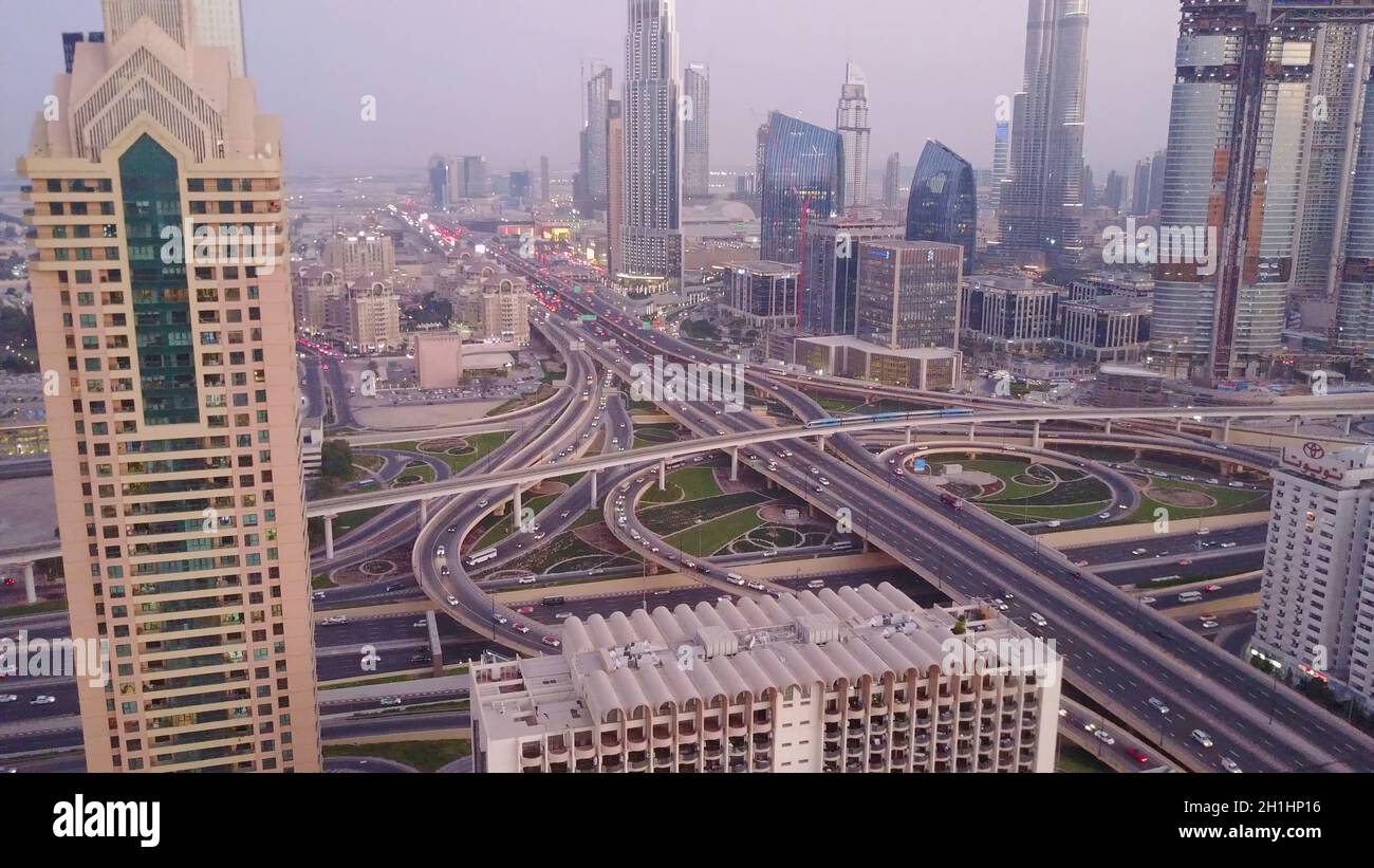 Vue sur les gratte-ciels modernes et les autoroutes animées le soir dans le centre-ville de luxe de Dubaï.Vue aérienne supérieure depuis le toit de la tour.Circulation aux intersections. Banque D'Images