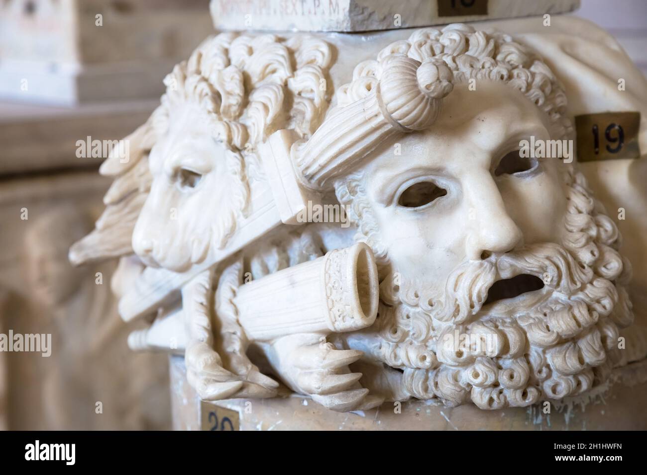 Ancien masque de théâtre, en marbre, situé à la base d'une colonne romaine à Rome - Italie Banque D'Images